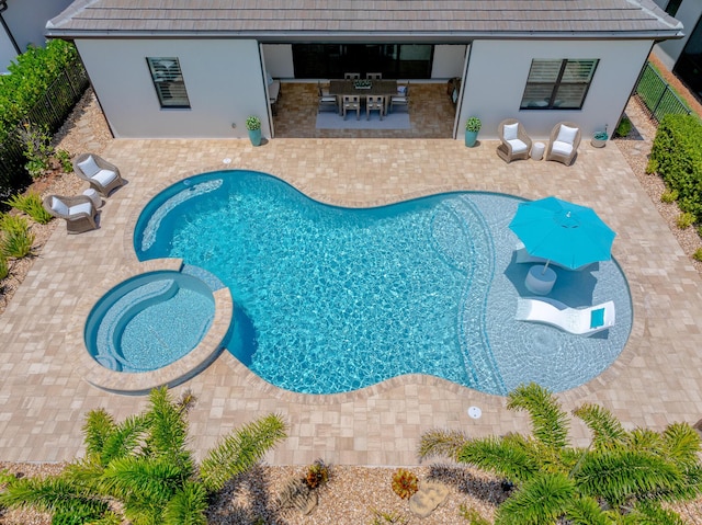 640 SE Boboli Way, Port Saint Lucie, FL 34984 - view of swimming pool featuring a patio area, a pool with connected hot tub, a fenced backyard, and outdoor dining area