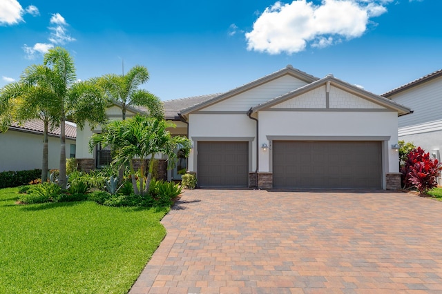 640 SE Boboli Way, Port Saint Lucie, FL 34984 - view of front of house featuring stone siding, a garage, a front lawn, and stucco siding