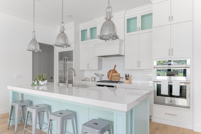 640 SE Boboli Way, Port Saint Lucie, FL 34984 - kitchen with appliances with stainless steel finishes, light countertops, backsplash, a kitchen island with sink, and a breakfast bar area