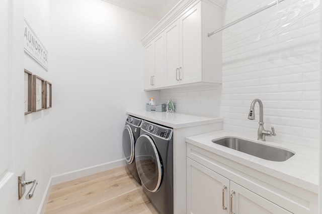 640 SE Boboli Way, Port Saint Lucie, FL 34984 - washroom featuring independent washer and dryer, cabinet space, light wood-style flooring, and baseboards