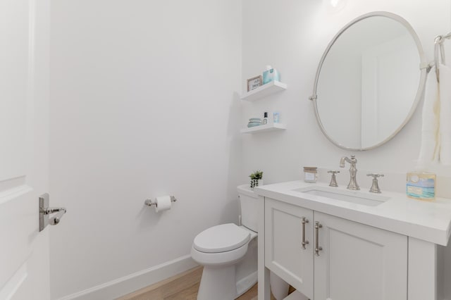 640 SE Boboli Way, Port Saint Lucie, FL 34984 - half bathroom featuring vanity, toilet, wood finished floors, and baseboards