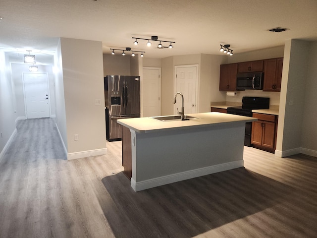 1721 SE Biddle Ln, Port Saint Lucie, FL 34983 - kitchen with refrigerator with ice dispenser, a sink, stainless steel microwave, black range with electric stovetop, and light wood finished floors