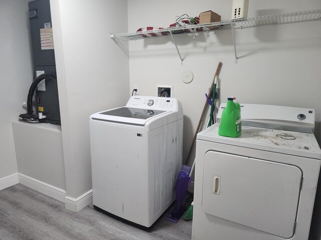 1721 SE Biddle Ln, Port Saint Lucie, FL 34983 - laundry room with independent washer and dryer, light wood-type flooring, and baseboards