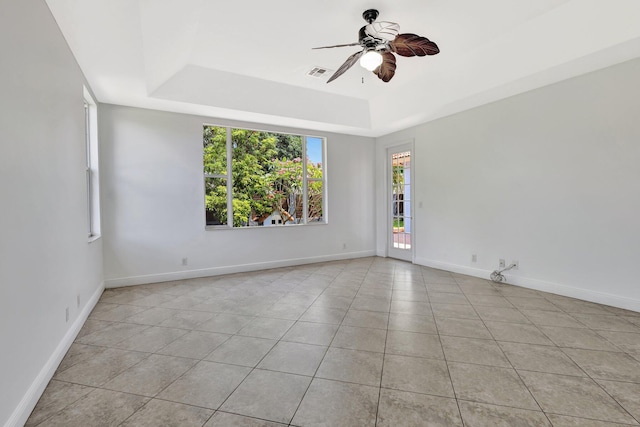 1897 SW Citation Ave, Port Saint Lucie, FL 34953 - empty room featuring a tray ceiling, a ceiling fan, light tile patterned floors, and baseboards