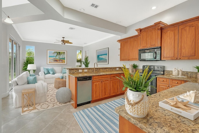 1897 SW Citation Ave, Port Saint Lucie, FL 34953 - kitchen featuring stainless steel appliances, a peninsula, open floor plan, light stone countertops, and brown cabinetry