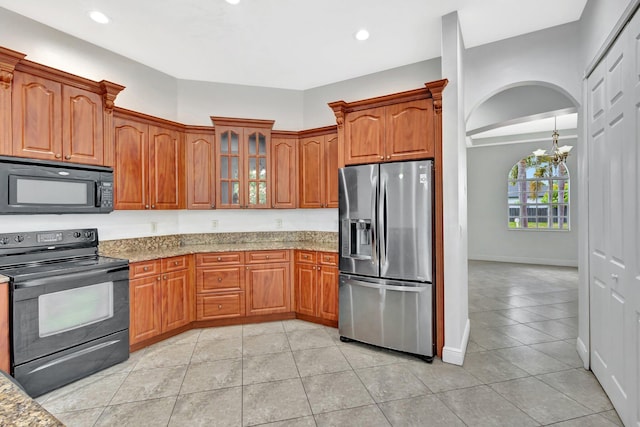 1897 SW Citation Ave, Port Saint Lucie, FL 34953 - kitchen featuring black appliances, light stone countertops, a chandelier, glass insert cabinets, and recessed lighting