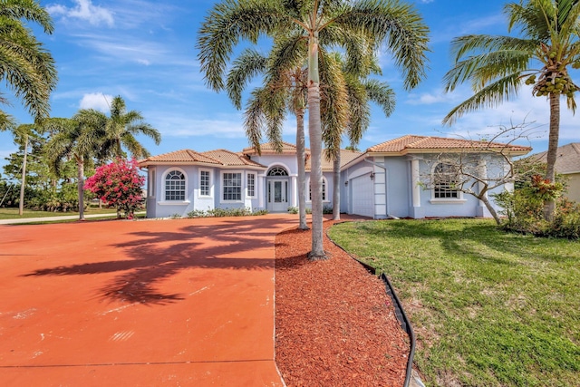 1897 SW Citation Ave, Port Saint Lucie, FL 34953 - mediterranean / spanish-style home with a tiled roof, stucco siding, an attached garage, a front yard, and concrete driveway