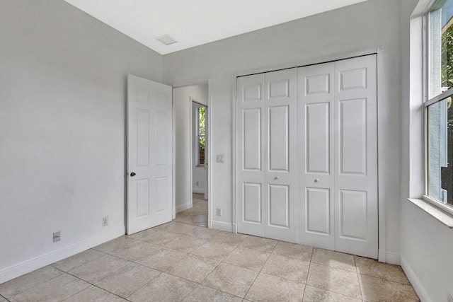 1897 SW Citation Ave, Port Saint Lucie, FL 34953 - unfurnished bedroom featuring light tile patterned flooring, a closet, and baseboards