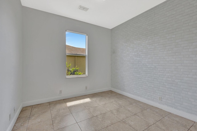 1897 SW Citation Ave, Port Saint Lucie, FL 34953 - spare room featuring brick wall, baseboards, and light tile patterned flooring