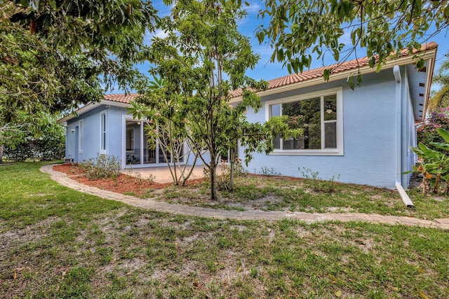 1897 SW Citation Ave, Port Saint Lucie, FL 34953 - view of front of property featuring a tiled roof, a front yard, stucco siding, and a patio area