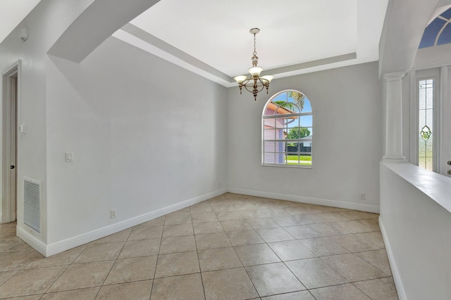 1897 SW Citation Ave, Port Saint Lucie, FL 34953 - empty room with healthy amount of natural light, a chandelier, a tray ceiling, and tile patterned flooring