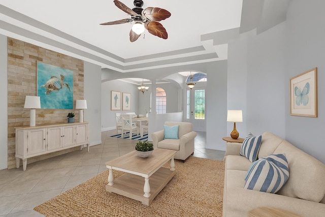 1897 SW Citation Ave, Port Saint Lucie, FL 34953 - living area with arched walkways, light tile patterned floors, a tray ceiling, a ceiling fan, and a chandelier