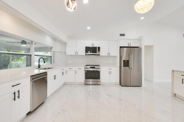 4873 SE Pilot Way, Stuart, FL 34997 - kitchen with stainless steel appliances, a sink, lofted ceiling, tasteful backsplash, and white cabinetry
