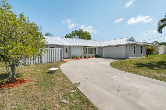 4873 SE Pilot Way, Stuart, FL 34997 - single story home with stucco siding, metal roof, an attached garage, concrete driveway, and a standing seam roof