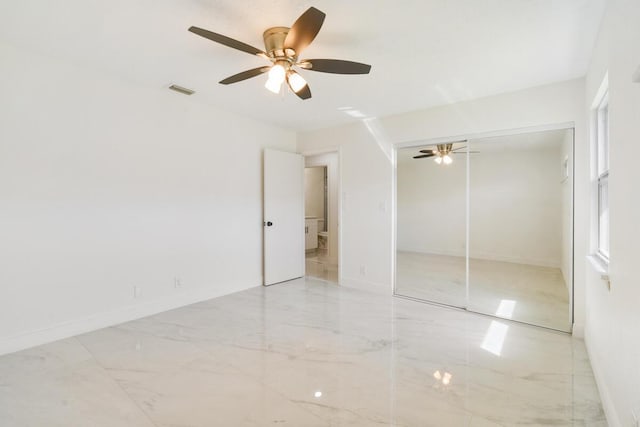 4873 SE Pilot Way, Stuart, FL 34997 - unfurnished bedroom featuring marble finish floors, a closet, ceiling fan, and baseboards