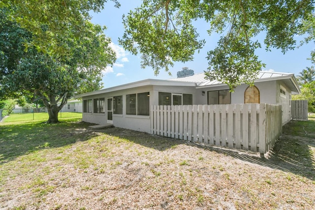 4873 SE Pilot Way, Stuart, FL 34997 - back of property with a chimney, a sunroom, a standing seam roof, stucco siding, and metal roof