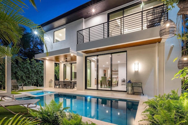 775 Park Dr W, Boca Raton, FL 33432 - back of house at night with a balcony, stucco siding, and a patio area