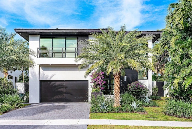 775 Park Dr W, Boca Raton, FL 33432 - view of front facade featuring a garage, a balcony, stucco siding, and decorative driveway