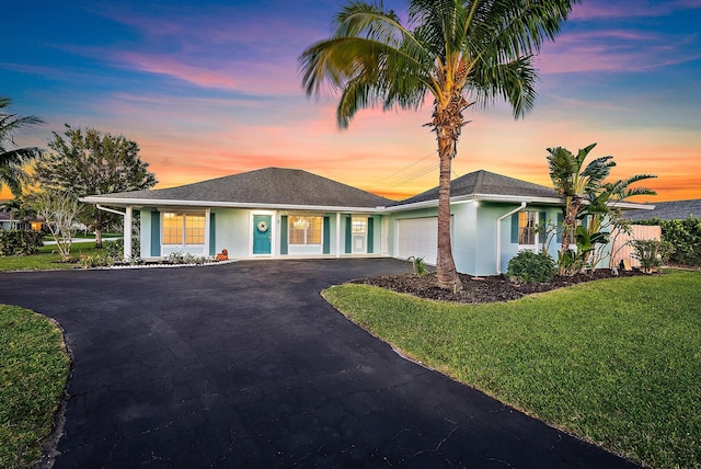 3 SE Paddock Cir, Jupiter, FL 33469 - ranch-style house featuring an attached garage, driveway, a front lawn, and stucco siding