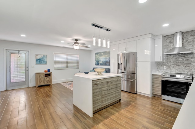 187 Seville H, Delray Beach, FL 33446 - kitchen with wall chimney exhaust hood, stainless steel appliances, modern cabinets, light countertops, and white cabinets