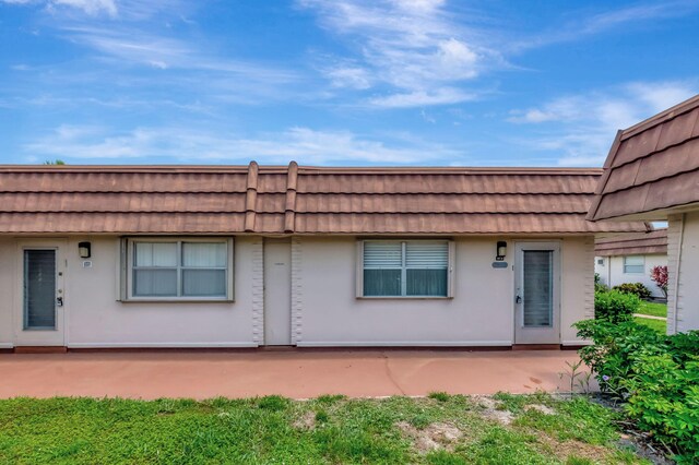 187 Seville H, Delray Beach, FL 33446 - back of house with mansard roof and a patio area