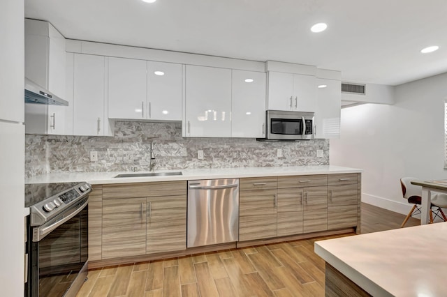 187 Seville H, Delray Beach, FL 33446 - kitchen with stainless steel appliances, a sink, modern cabinets, white cabinetry, and light countertops