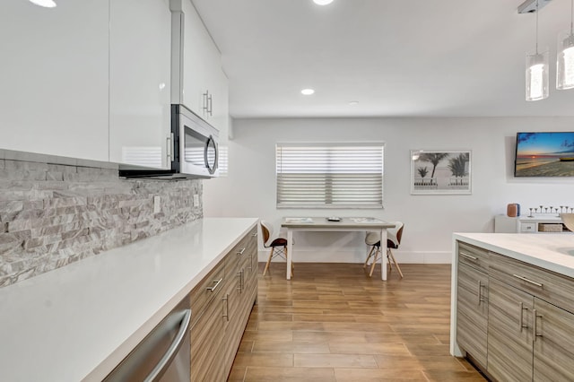 187 Seville H, Delray Beach, FL 33446 - kitchen featuring stainless steel microwave, backsplash, light countertops, baseboards, and recessed lighting