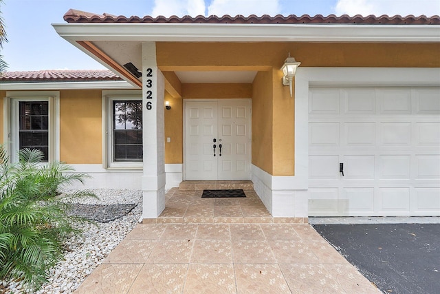 2326 NW 96th Way, Coral Springs, FL 33065 - doorway to property featuring a garage, stucco siding, and a tiled roof