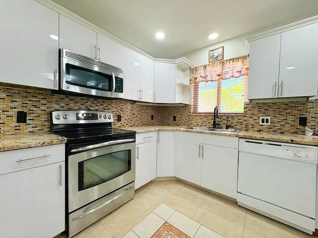1034 Almeria Rd, West Palm Beach, FL 33405 - kitchen featuring stainless steel appliances, a sink, white cabinetry, and light tile patterned flooring