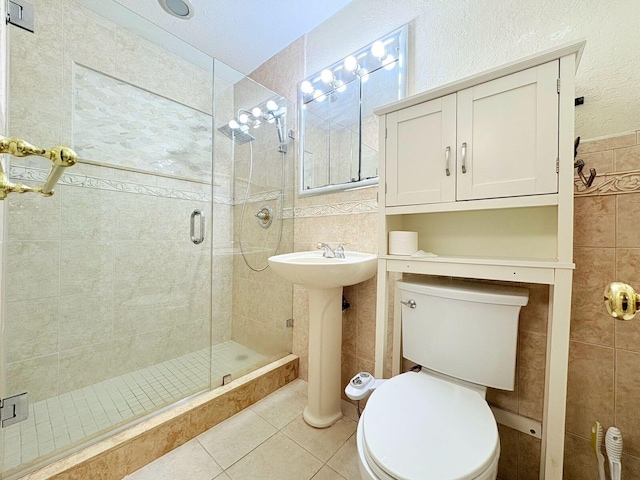 1034 Almeria Rd, West Palm Beach, FL 33405 - full bathroom featuring tile patterned flooring, a shower stall, toilet, and tile walls