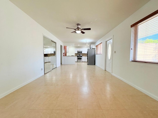 1034 Almeria Rd, West Palm Beach, FL 33405 - unfurnished living room featuring ceiling fan, baseboards, and light tile patterned flooring