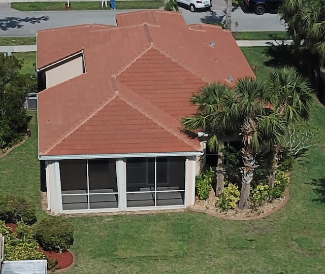 5704 Spanish River Rd, Fort Pierce, FL 34951 - rear view of house featuring a tiled roof, a yard, and a sunroom