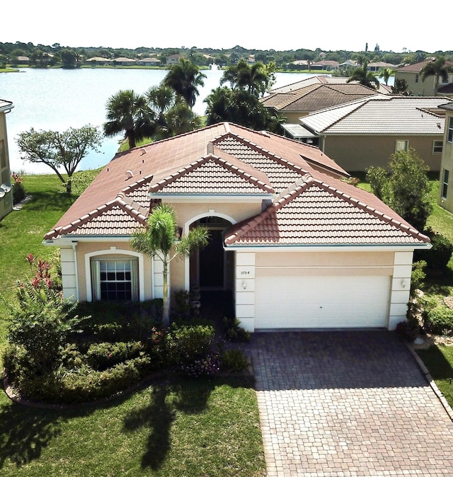 5704 Spanish River Rd, Fort Pierce, FL 34951 - view of front of house featuring a tiled roof, a garage, driveway, and a water view