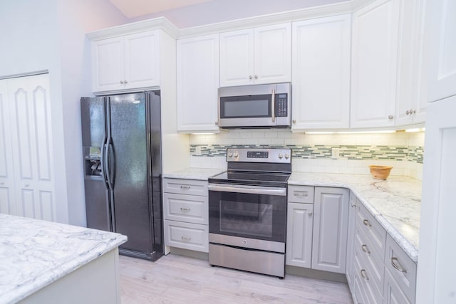 5704 Spanish River Rd, Fort Pierce, FL 34951 - kitchen with appliances with stainless steel finishes, decorative backsplash, white cabinetry, light wood-style floors, and light stone countertops
