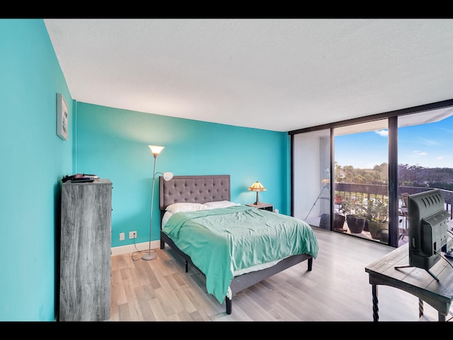 2400 Presidential Way Unit 401, West Palm Beach, FL 33401 - bedroom featuring wood finished floors, baseboards, and a wall of windows
