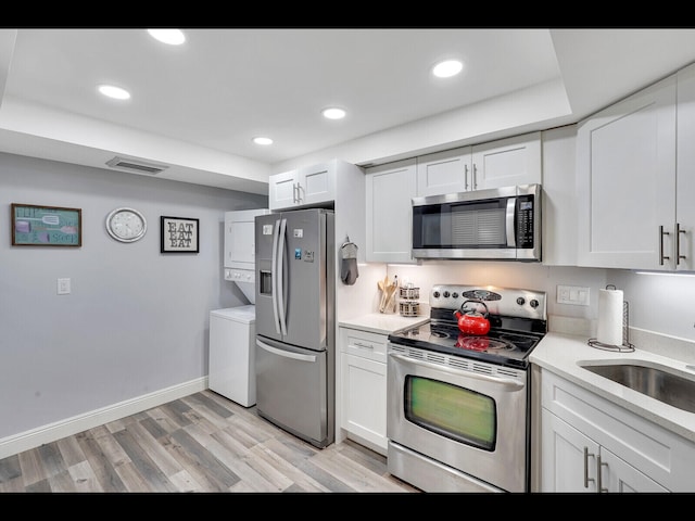2400 Presidential Way Unit 401, West Palm Beach, FL 33401 - kitchen featuring appliances with stainless steel finishes, light countertops, light wood finished floors, white cabinetry, and recessed lighting