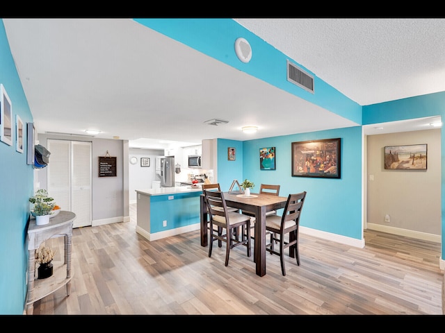 2400 Presidential Way Unit 401, West Palm Beach, FL 33401 - dining space with light wood-style floors and baseboards