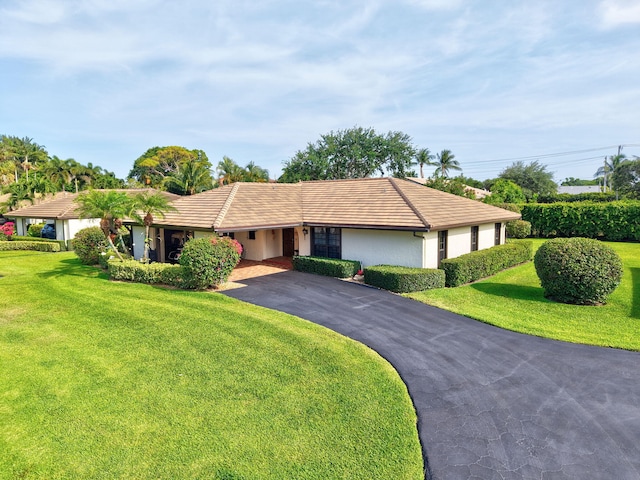 438 Pine Villa Dr, Atlantis, FL 33462 - single story home featuring driveway, a tile roof, a front yard, stucco siding, and a carport