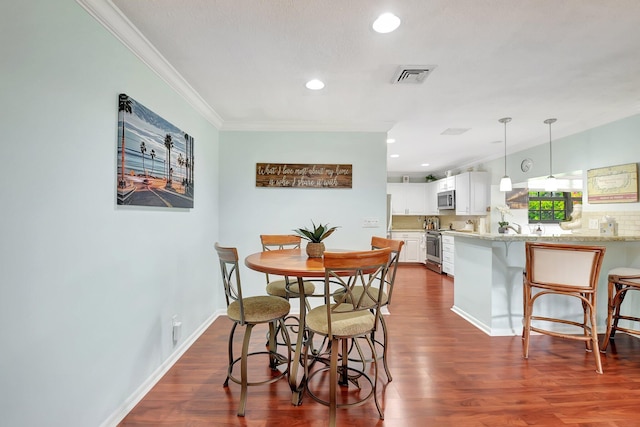 438 Pine Villa Dr, Atlantis, FL 33462 - dining area with crown molding, dark wood-style flooring, recessed lighting, and baseboards