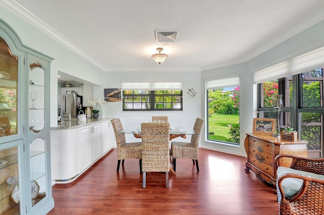 438 Pine Villa Dr, Atlantis, FL 33462 - dining room featuring crown molding, dark wood-style flooring, and a textured ceiling