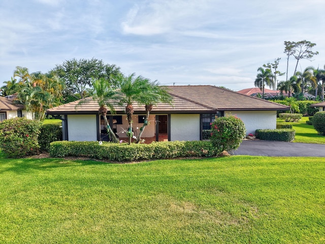 438 Pine Villa Dr, Atlantis, FL 33462 - ranch-style house featuring a front lawn, stucco siding, and a tile roof
