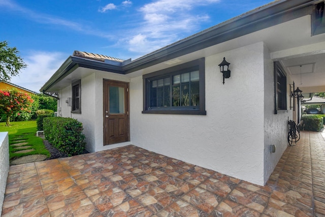 438 Pine Villa Dr, Atlantis, FL 33462 - entrance to property featuring stucco siding and a patio