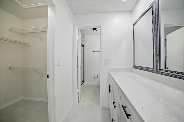 5242 Privet Pl Unit C, Delray Beach, FL 33484 - full bathroom featuring a stall shower, vanity, tile patterned flooring, a walk in closet, and baseboards