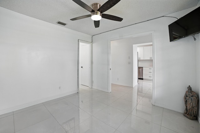 5242 Privet Pl Unit C, Delray Beach, FL 33484 - spare room featuring a textured ceiling, a ceiling fan, baseboards, and light tile patterned floors