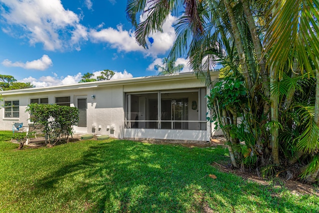 5242 Privet Pl Unit C, Delray Beach, FL 33484 - back of property with stucco siding, a yard, and a sunroom