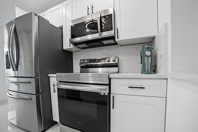 5242 Privet Pl Unit C, Delray Beach, FL 33484 - kitchen with stainless steel appliances, white cabinets, and light tile patterned floors