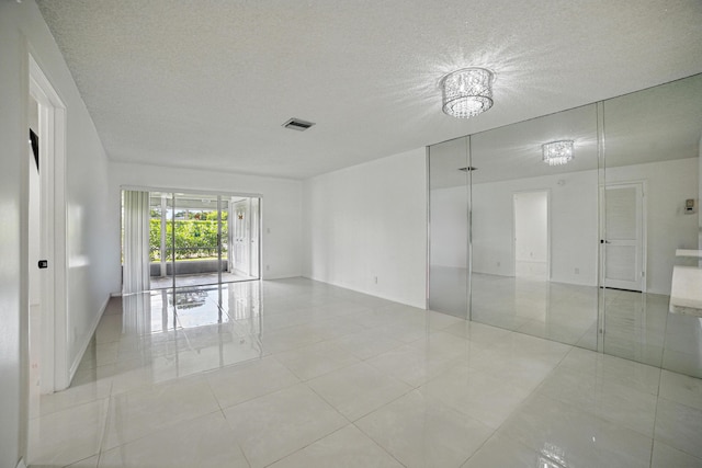 5242 Privet Pl Unit C, Delray Beach, FL 33484 - tiled empty room featuring a textured ceiling