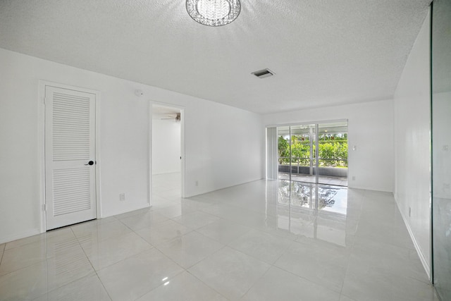 5242 Privet Pl Unit C, Delray Beach, FL 33484 - unfurnished room with a textured ceiling and light tile patterned floors