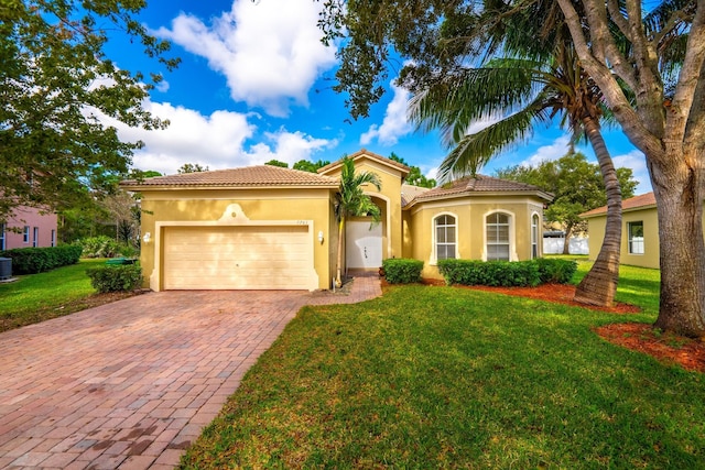 5761 Spanish River Rd, Fort Pierce, FL 34951 - mediterranean / spanish home featuring decorative driveway, stucco siding, an attached garage, a front yard, and a tiled roof