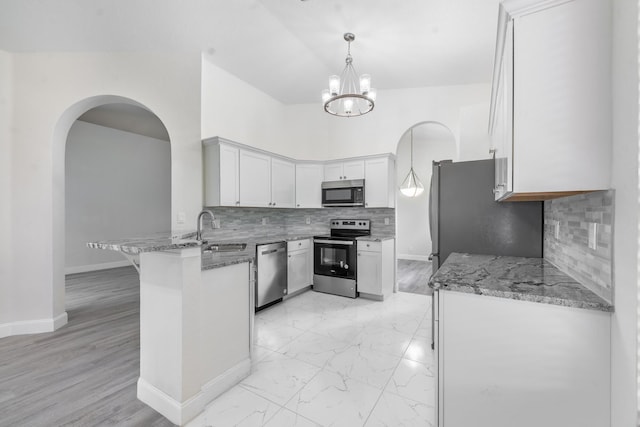 5761 Spanish River Rd, Fort Pierce, FL 34951 - kitchen featuring appliances with stainless steel finishes, a sink, a peninsula, and light stone countertops